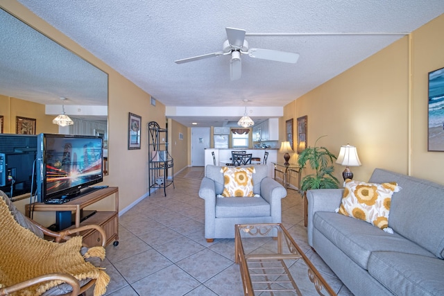 living room featuring light tile patterned flooring, ceiling fan, and a textured ceiling