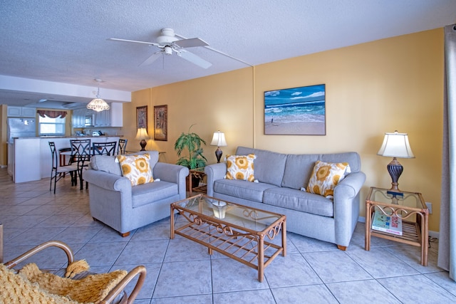 tiled living room featuring ceiling fan and a textured ceiling