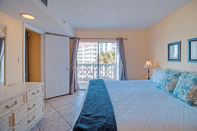 bedroom with access to exterior, light tile patterned floors, and a textured ceiling