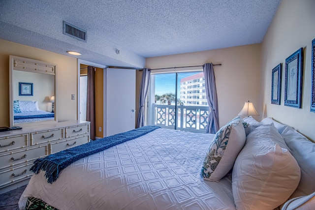 bedroom with access to outside and a textured ceiling