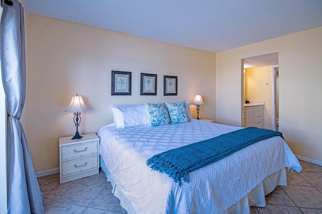 tiled bedroom featuring connected bathroom and a textured ceiling