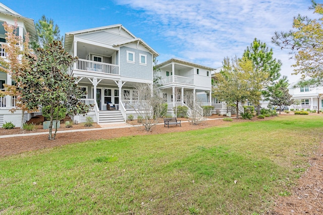 back of property featuring a balcony and a yard