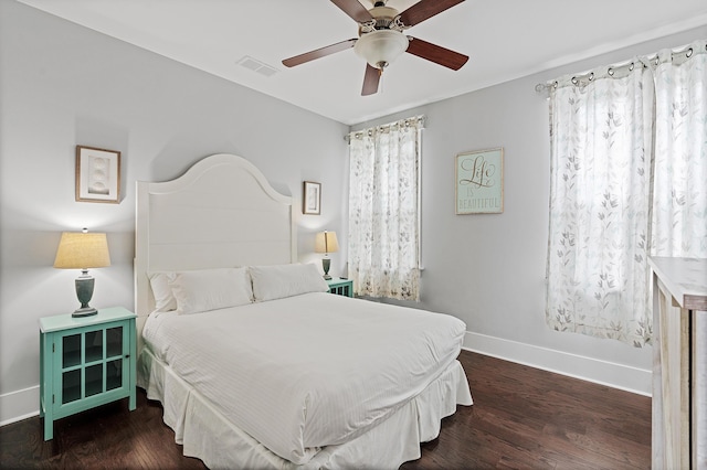 bedroom with dark hardwood / wood-style flooring and ceiling fan