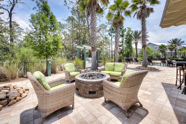 view of patio with an outdoor living space with a fire pit