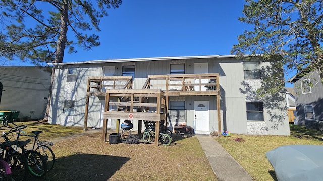 view of front facade featuring a balcony and a front yard