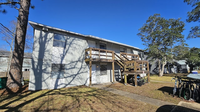 back of property with a wooden deck and a yard