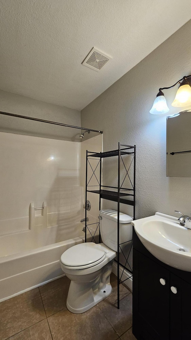 full bathroom featuring shower / washtub combination, vanity, a textured ceiling, tile patterned floors, and toilet