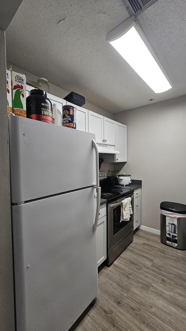 kitchen featuring white cabinetry, a textured ceiling, light wood-type flooring, electric range, and white fridge