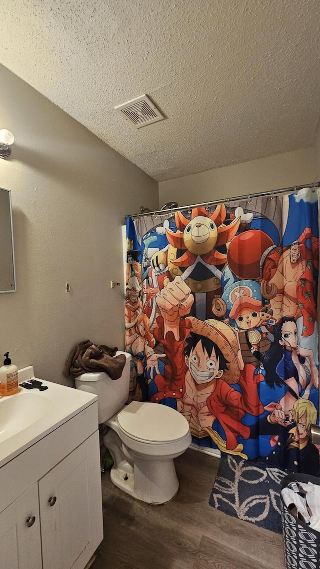 bathroom with toilet, a shower with curtain, a textured ceiling, vanity, and hardwood / wood-style flooring