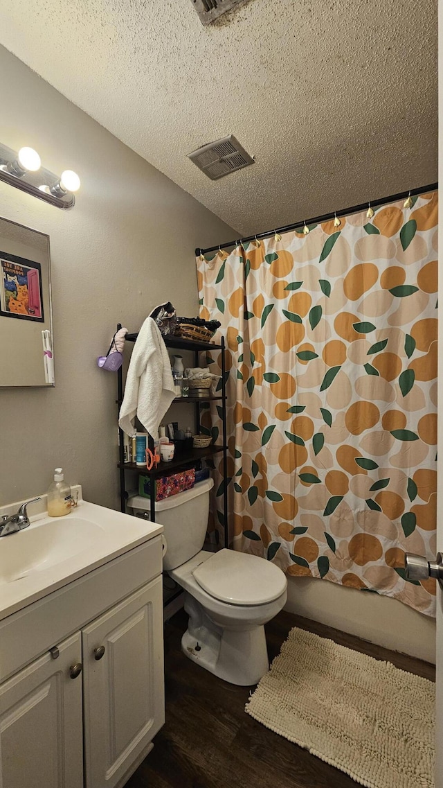 bathroom featuring vanity, hardwood / wood-style floors, toilet, and a textured ceiling