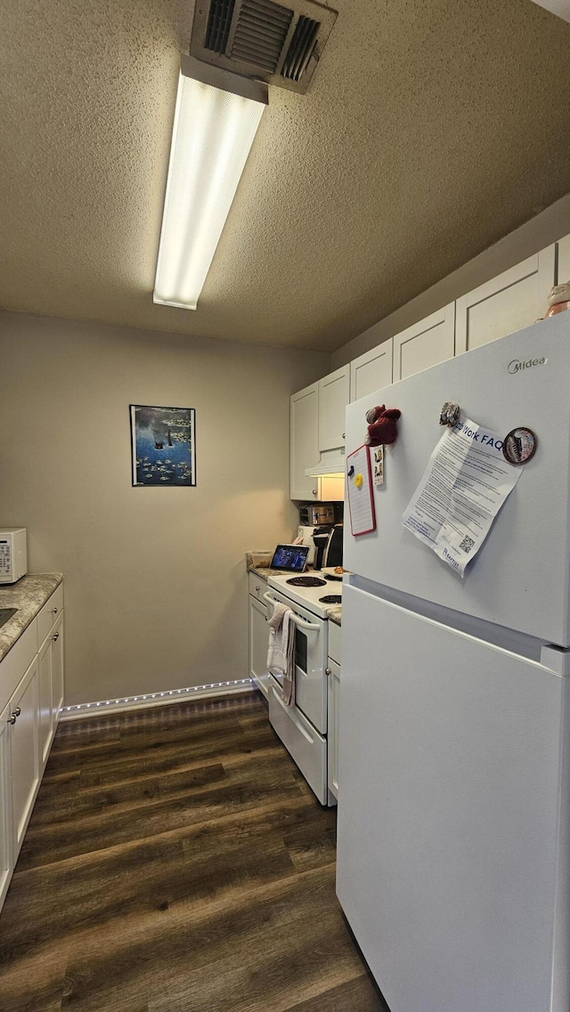 kitchen featuring white cabinetry, dark wood-type flooring, a textured ceiling, and white appliances