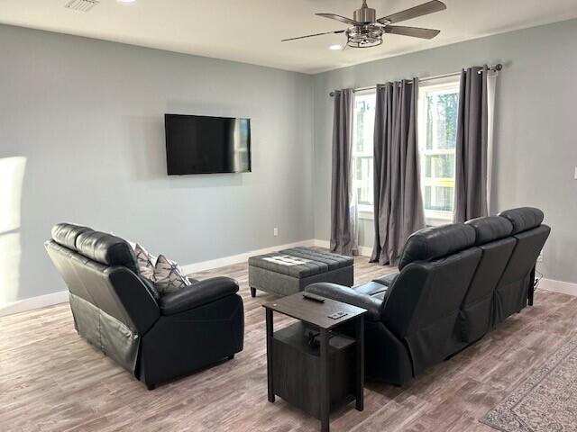 living room featuring wood-type flooring and ceiling fan