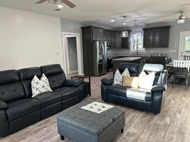 living room featuring ceiling fan and light wood-type flooring