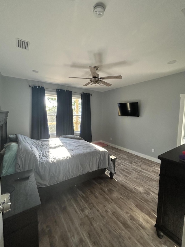 bedroom with dark hardwood / wood-style floors and ceiling fan