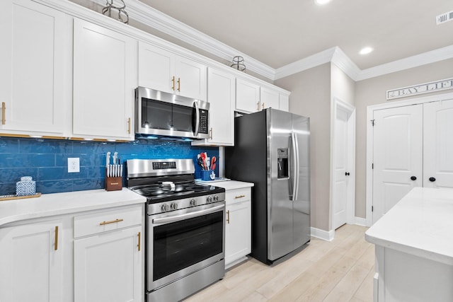 kitchen with backsplash, crown molding, stainless steel appliances, and white cabinets