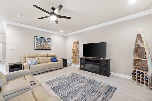 living room featuring crown molding, ceiling fan, and light hardwood / wood-style floors