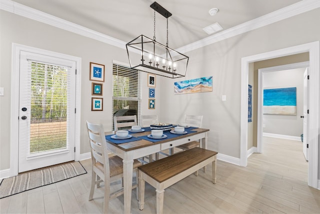 dining space with ornamental molding and light wood-type flooring