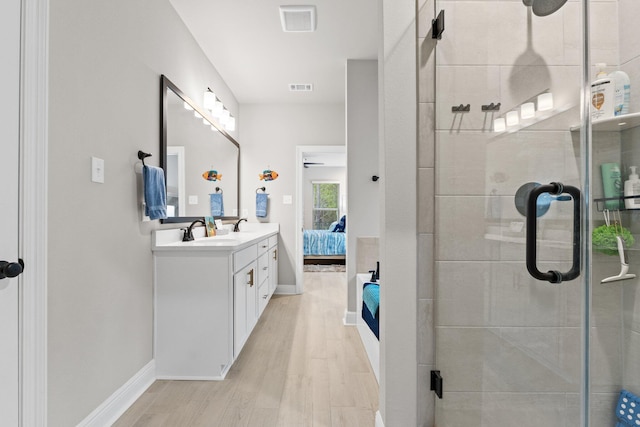 bathroom featuring hardwood / wood-style flooring, vanity, and a shower with door