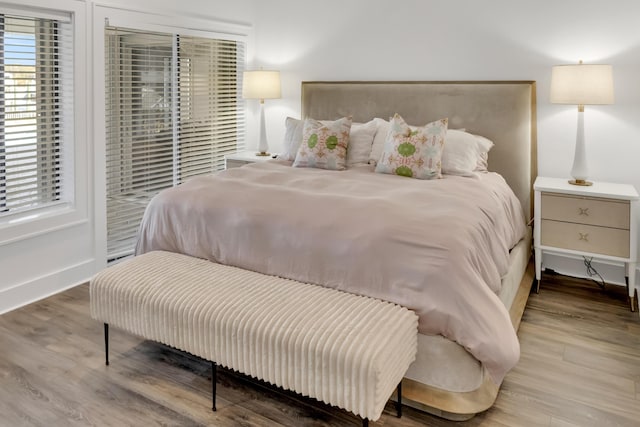 bedroom with access to exterior and wood-type flooring