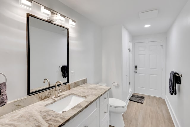 bathroom with vanity, toilet, and wood-type flooring