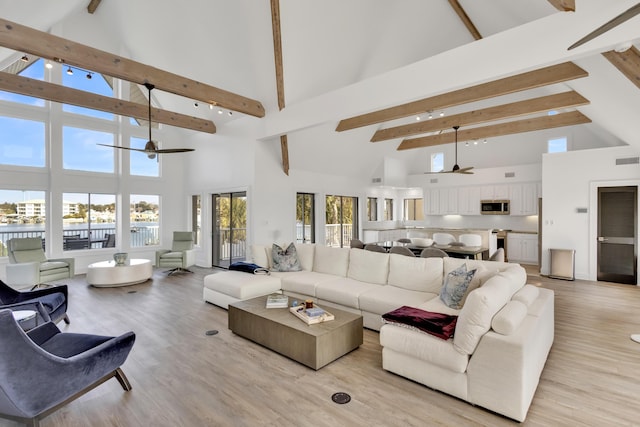 living room with beam ceiling, ceiling fan, high vaulted ceiling, and light hardwood / wood-style floors