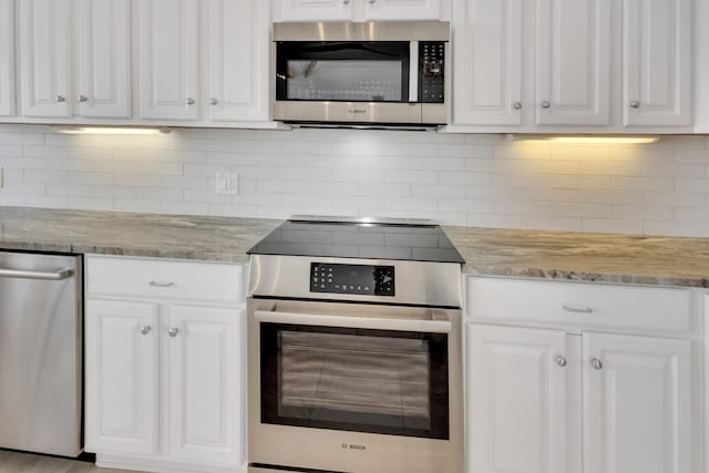 kitchen with white cabinetry, decorative backsplash, stainless steel appliances, and light stone counters