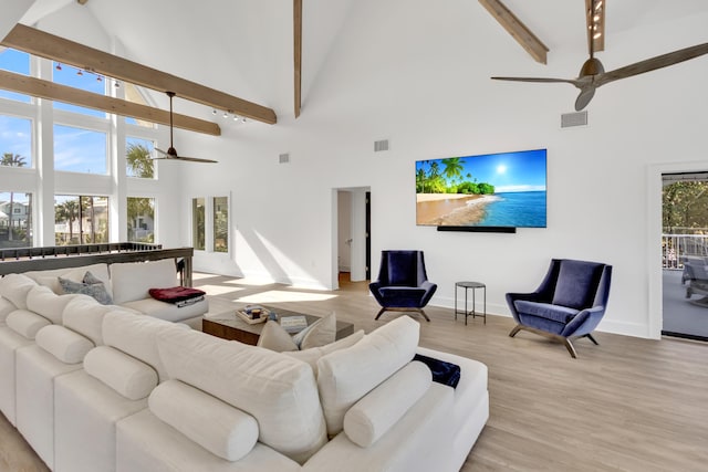 living room featuring beam ceiling, high vaulted ceiling, ceiling fan, and light wood-type flooring