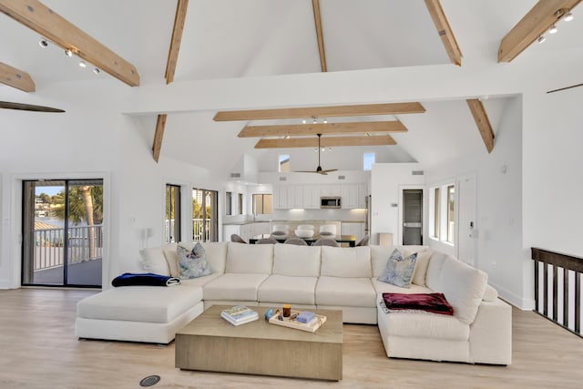 living room featuring light hardwood / wood-style flooring, high vaulted ceiling, and beamed ceiling