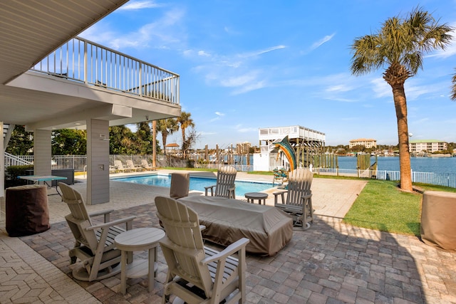 view of swimming pool with a patio and a water view