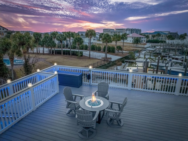 deck at dusk featuring a fire pit and a boat dock