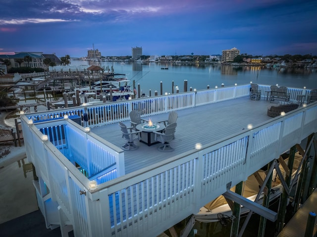 view of dock featuring a deck with water view and an outdoor fire pit