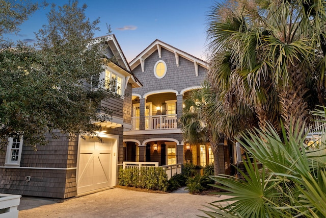 view of front of house featuring a balcony, a garage, and covered porch