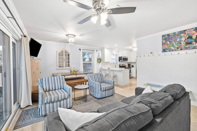 living room with crown molding, ceiling fan, and light tile patterned flooring