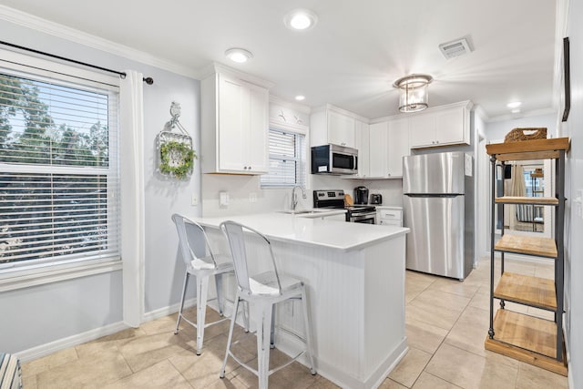 kitchen featuring sink, light tile patterned floors, appliances with stainless steel finishes, white cabinets, and kitchen peninsula