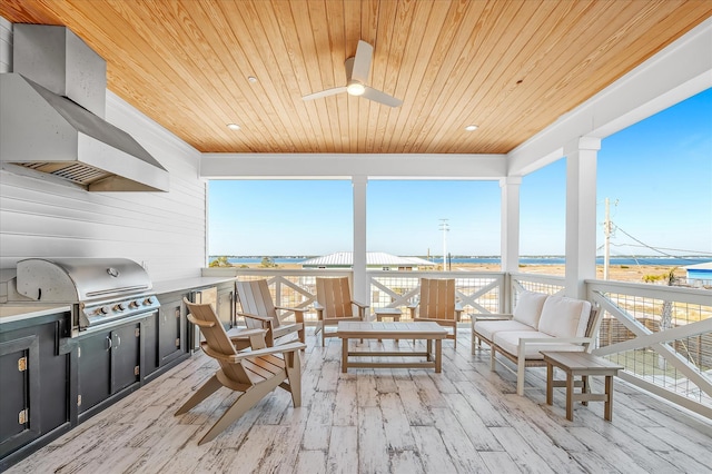 sunroom / solarium featuring wood ceiling, ceiling fan, and a water view