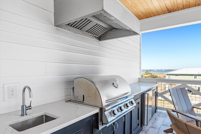 view of patio featuring area for grilling, sink, and a water view