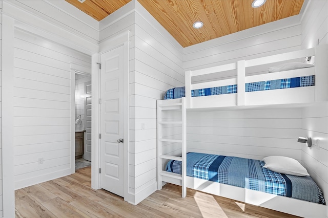 bedroom with wood ceiling and wood walls