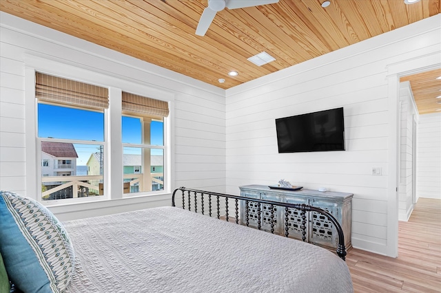 bedroom featuring wood ceiling, ceiling fan, wood-type flooring, and wooden walls