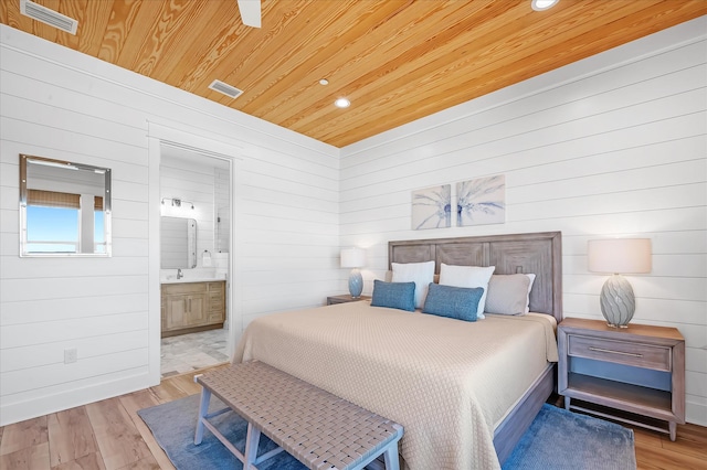 bedroom with wooden ceiling, ensuite bath, and light hardwood / wood-style flooring