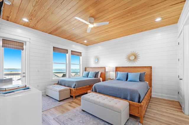 bedroom featuring wood ceiling, light wood-type flooring, ceiling fan, and a water view