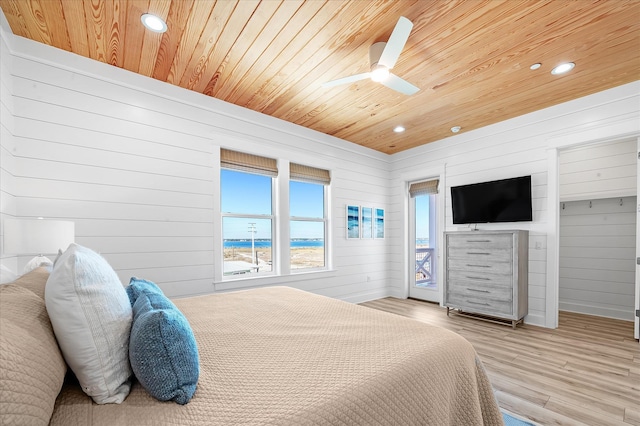 bedroom with ceiling fan, wood walls, light hardwood / wood-style flooring, and wooden ceiling