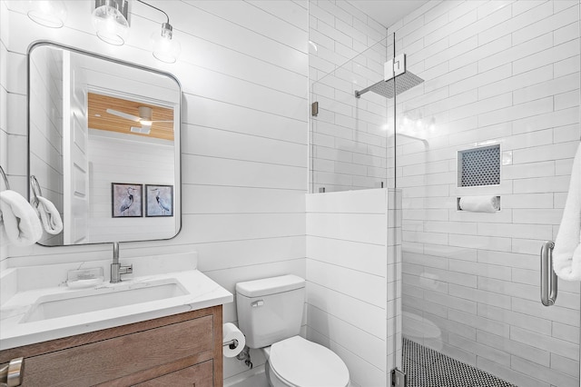 bathroom featuring vanity, a shower with door, and toilet