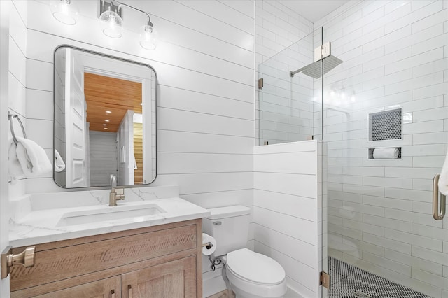 bathroom featuring vanity, toilet, and a shower with door