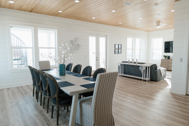 dining room with french doors, plenty of natural light, wood ceiling, and light hardwood / wood-style flooring