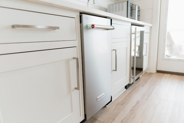 details featuring hardwood / wood-style flooring and wine cooler