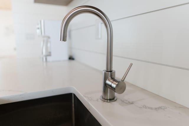 interior details featuring sink and light stone countertops