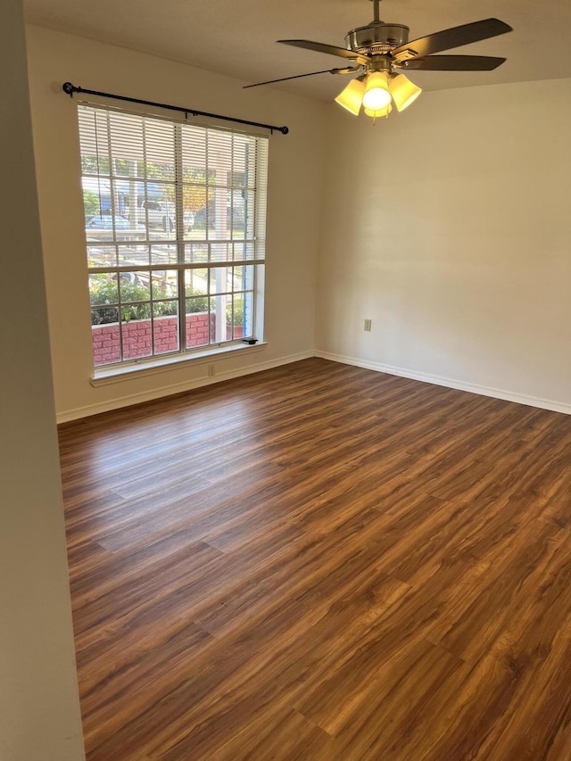 spare room featuring dark wood-type flooring and ceiling fan