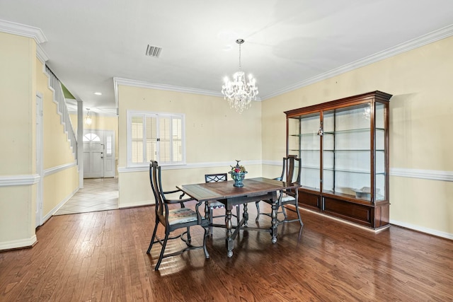 dining room featuring ornamental molding, dark hardwood / wood-style flooring, and a chandelier