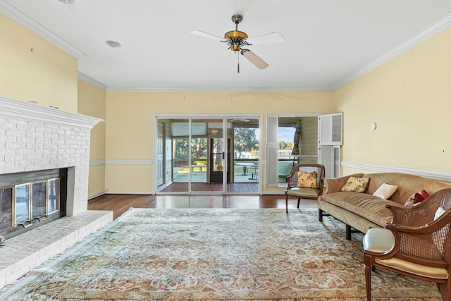 living room featuring crown molding, ceiling fan, a fireplace, and dark hardwood / wood-style flooring