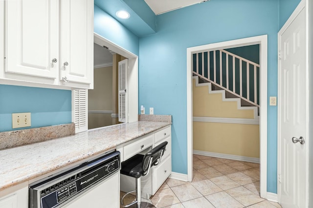 kitchen with dishwasher, light tile patterned floors, white cabinets, and light stone counters